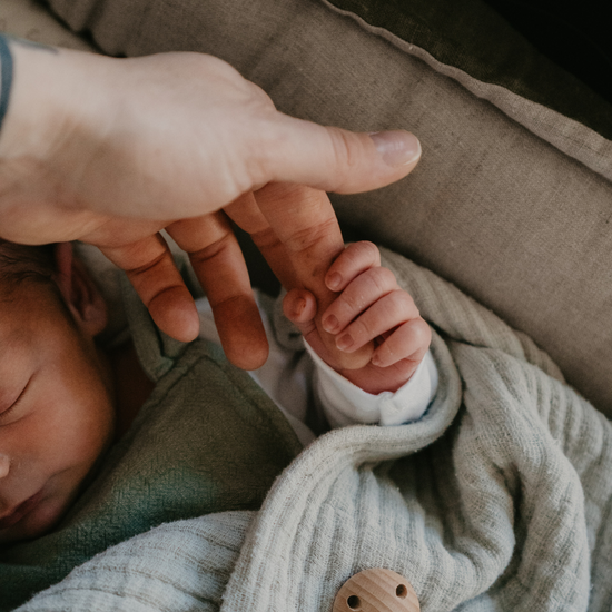 Nyfødt der holder om sin mors finger